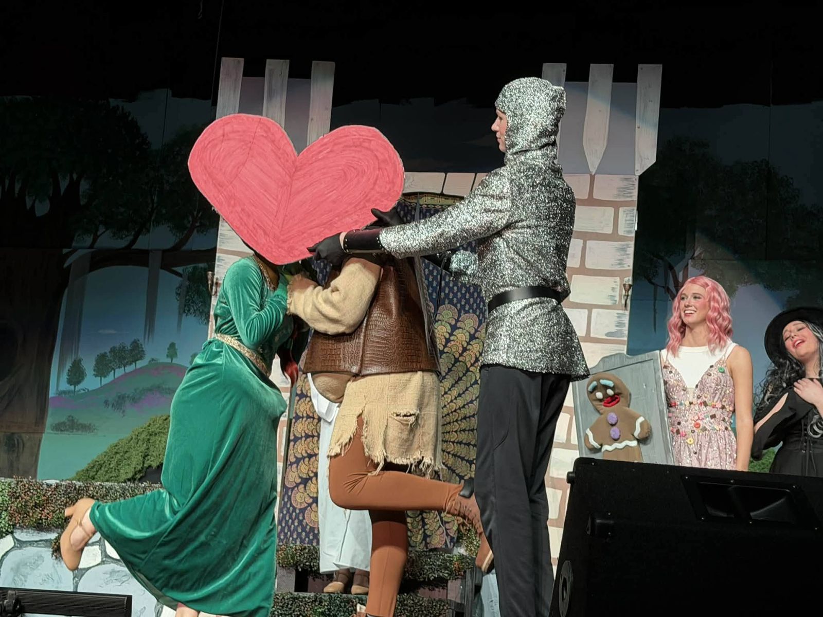 Fiona and Shrek behind a big paper heart